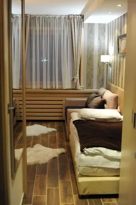 a bedroom with two beds and a window with curtains at Apartman Mitra Angella Konaci in Kopaonik
