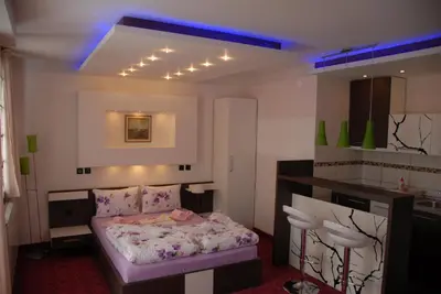 a small bedroom with a bed and a kitchen at Villa Milmari in Kopaonik