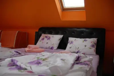 a bed with purple and white sheets and pillows at Villa Milmari in Kopaonik