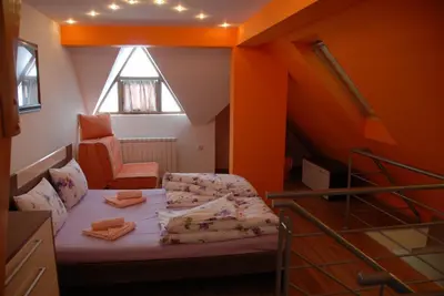 a room with a bed in a room with an attic at Villa Milmari in Kopaonik