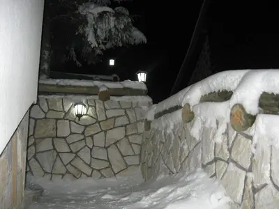 a stone wall covered in snow at night at Villa Sofija in Kopaonik