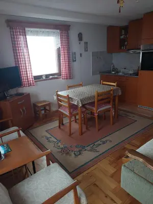 a living room with a table and chairs and a kitchen at Villa Sofija in Kopaonik