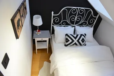 a bedroom with a bed with a black and white headboard at Višnja apartment in Kopaonik