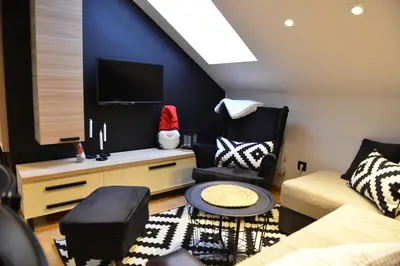 a living room with a couch and a tv at Višnja apartment in Kopaonik