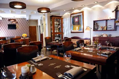 a restaurant with wooden tables and chairs and a bar at Hotel Kraljevi Čardaci in Kopaonik