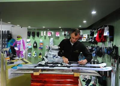 a man is cutting a cake in a shop at Hotel Kraljevi Čardaci in Kopaonik