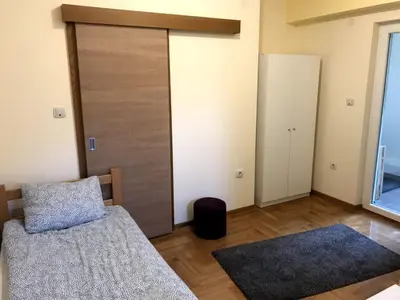 a bedroom with a bed and a sliding door at GOski Apartman Brzeće Kopaonik in Brzeće
