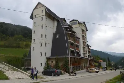 a large white building with a black roof at GOski Apartman Brzeće Kopaonik in Brzeće