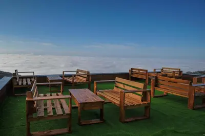 a group of wooden benches and tables on the grass at Milmari Resort, Apartman Premier 27 in Kopaonik