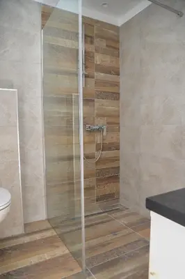 a shower with a glass door in a bathroom at Milmari Resort, Apartman Premier 27 in Kopaonik