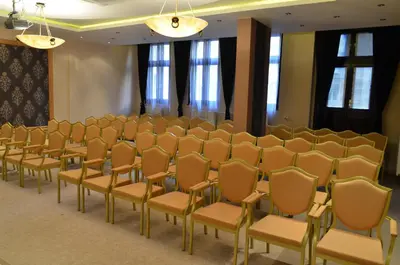 a row of chairs in a room with windows at The Regent Club Hotel in Niš