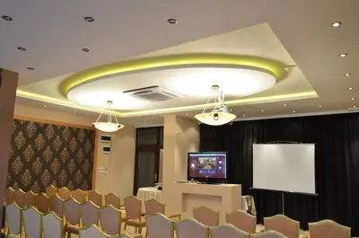 a conference room with a table and chairs and a screen at The Regent Club Hotel in Niš