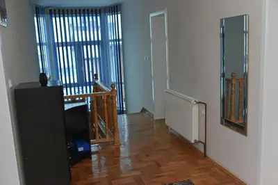 a living room with a staircase and a room with a stair case at Blue House Apartment in Niš