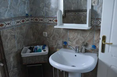 a bathroom with a sink and a mirror at Blue House Apartment in Niš