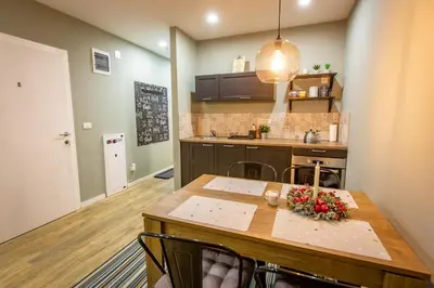 a kitchen with a wooden table and a dining room at View - Apartment at Kopaonik in Kopaonik