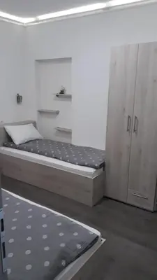 a bedroom with a bed and a cabinet in it at Smestaj Pandora Sobe sa kupatilom in Jagodina