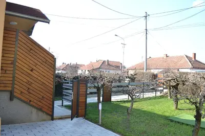 a backyard with a wooden fence and some trees at Smestaj Pandora Sobe sa kupatilom in Jagodina