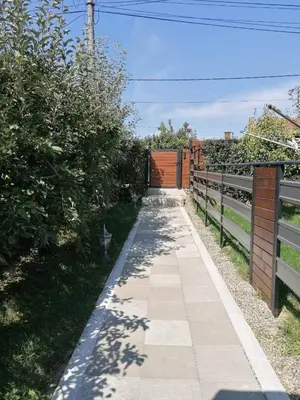 a sidewalk with a fence and a orange gate at Smestaj Pandora Sobe sa kupatilom in Jagodina