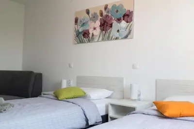 a bedroom with two beds and a painting on the wall at La Casa in Niš