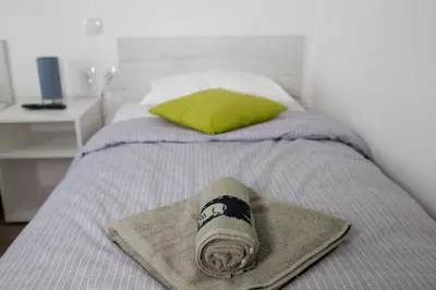 a bed with a hat and a towel on it at La Casa in Niš