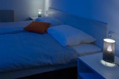 a blue bedroom with a bed with pillows and a table at La Casa in Niš