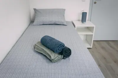a bed with a blue towel on top of it at La Casa in Niš