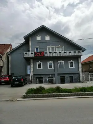 a large gray building with a sign on it at La Casa in Niš