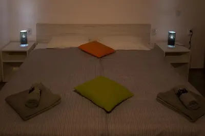 a bed with two pillows and slippers on it at La Casa in Niš