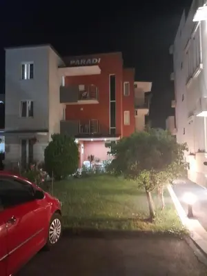 a red car parked in front of a building at night at Vila Paradi in Vrnjačka Banja