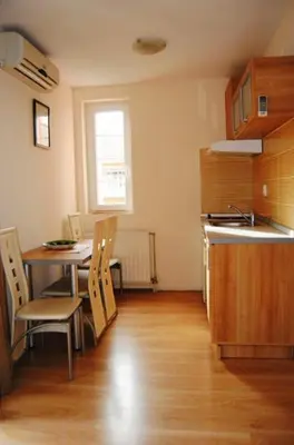 a kitchen with a table and chairs and a sink at Vila Paradi in Vrnjačka Banja