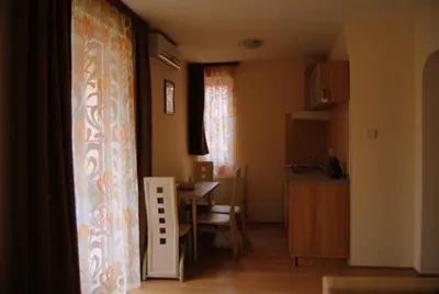 a kitchen and dining room with a table and a room with a kitchen at Vila Paradi in Vrnjačka Banja