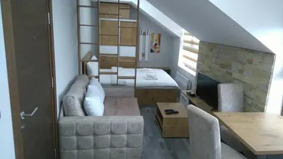 a living room with a bed and a couch and a table at Milmari, Resort, Premier Apartman A52 & Parking garage FREE in Kopaonik