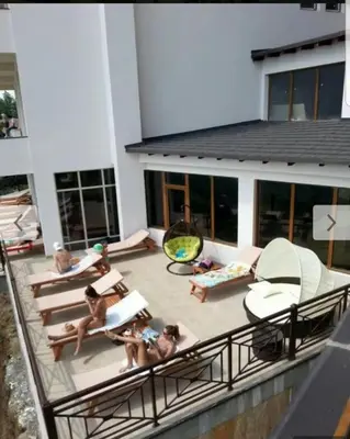 a group of people sitting on a patio outside of a building at Milmari, Resort, Premier Apartman A52 & Parking garage FREE in Kopaonik