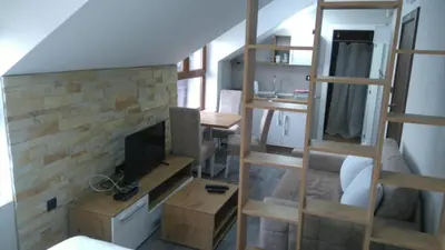 a living room with a staircase and a fireplace at Milmari, Resort, Premier Apartman A52 & Parking garage FREE in Kopaonik
