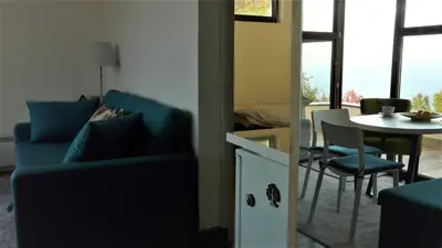 a living room with a blue couch and a table at Apartman D52 Dvori in Kopaonik