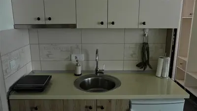 a kitchen counter top with a sink and a counter top at Apartman D52 Dvori in Kopaonik