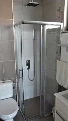 a bathroom with a shower with a toilet and a sink at Apartman D52 Dvori in Kopaonik