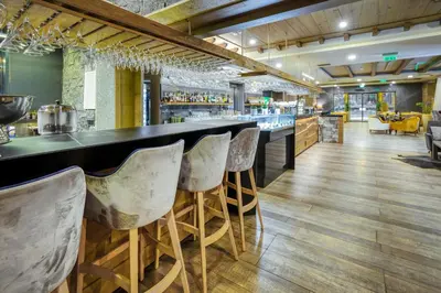 a bar with a row of chairs in a restaurant at Gorski Hotel & Spa in Kopaonik