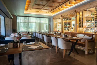 a restaurant with wooden tables and chairs and a bar at Gorski Hotel & Spa in Kopaonik
