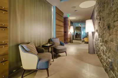 a waiting room with chairs and a stone wall at Gorski Hotel & Spa in Kopaonik