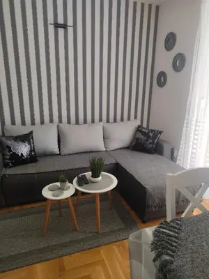 a living room with a couch and two tables at Apartman Harmonija Vrnjačka Banja in Vrnjačka Banja
