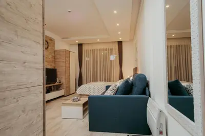 a living room with a blue couch and a mirror at Milmari L29 in Kopaonik