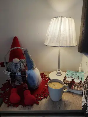 a table with a cup of coffee next to a lamp and a sock monkey at Milmari L29 in Kopaonik