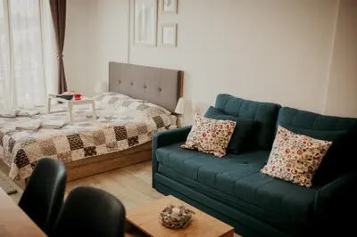 a living room with a blue couch and a bed at Milmari L29 in Kopaonik