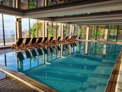 a swimming pool with chairs in a building at Milmari L29 in Kopaonik