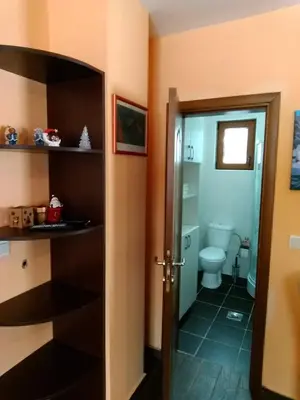 a bathroom with a toilet and a door open at Apartman Vila Natasa in Kopaonik