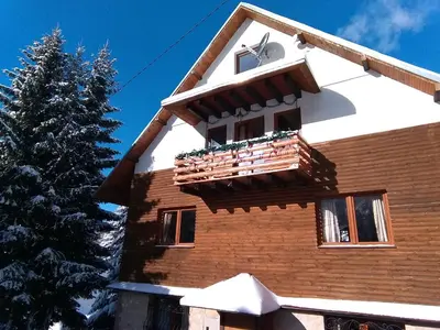 a house with a balcony and a christmas tree at Apartman Vila Natasa in Kopaonik