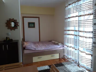 a small bedroom with a bed and a television at Apartmani Nebrigic in Brzeće