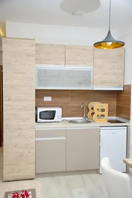 a kitchen with white cabinets and a microwave at Kophill L36 Milmari in Kopaonik