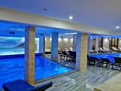 a swimming pool in a hotel with tables and chairs at Kophill L36 Milmari in Kopaonik